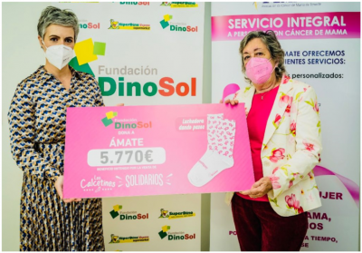 Se puede observar a la presidenta de la Fundación DinoSol Virginia Ávila junto a Carmen Bonfante, presidente de la Asociación AMATE,haciendo entrega del cheque con la recaudación de 5.770€ recaudados con la venta de los calcetines Luchadoras dando pasos.
