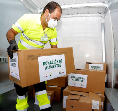 Repartidor HiperDino colocando las cajas de donaciones en el camión para realizar el reparto