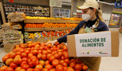 Trabajadora cogiendo tomates para donar a una entidad